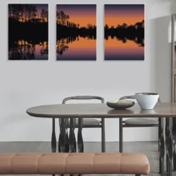 Solnedgång vid sjön - Triptyk - Serie om tre poster. En stämningsfull grafisk illustration där himlen tonas i starka orange och lila nyanser - Ramexempel