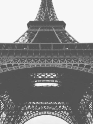 Paris Eiffel Tower - Poster. En kraftfull närbild i grodperspektiv av Eiffeltornet i Paris. Det svartvita fotografiet låter gråtonerna dominera